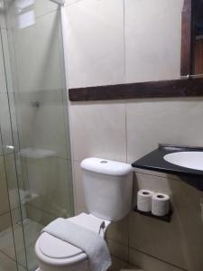 a bathroom with a toilet and a sink and a shower at Pousada pôr do sol in Riachuelo