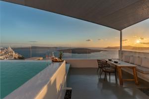 a villa with a swimming pool and a table and chairs at Thera Villas in Fira