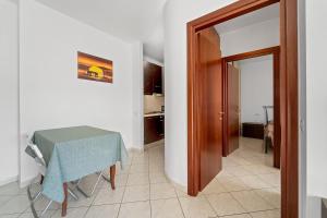 Zimmer mit einem Tisch, einem Tisch und einer Tür in der Unterkunft CagliariParadiseApartament Waves in Quartucciu