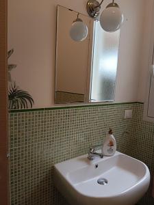 ein Bad mit einem Waschbecken und einem Spiegel in der Unterkunft Casa vacanze tizy in Ragusa