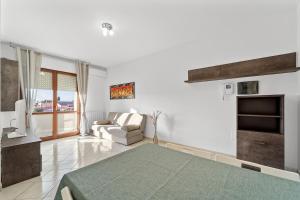 a bedroom with a bed and a couch and a fireplace at CagliariParadiseApartament Waves in Quartucciu