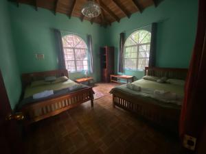 dwa łóżka w pokoju z zielonymi ścianami i dwoma oknami w obiekcie Inn the bush w mieście Big Eddy