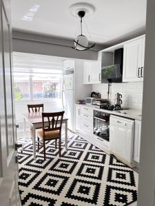 a kitchen with a table and a kitchen with white cabinets at an apartment in a decent neighborhood in Karşıyaka