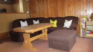 een woonkamer met een bank en een houten tafel bij Ferienwohnung am See 