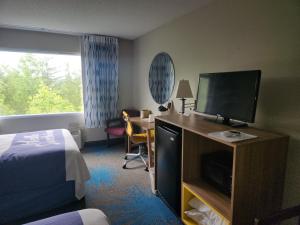 a hotel room with a bed and a flat screen tv at Days Inn by Wyndham Dahlonega University Area in Dahlonega