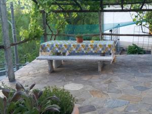 eine Bank auf einer Terrasse mit einem Tisch in der Unterkunft Casa Neva in Cannobio