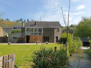 a large house with a yard with a river at LA FOLLE PARENTHESE in Vireux-Molhain