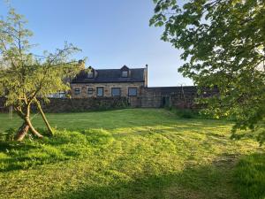 een oud stenen huis met een groene tuin bij The Smithy in Richmond