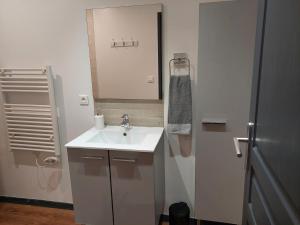 a white bathroom with a sink and a refrigerator at bel appart T2 confortable en plein coeur de Sigean in Sigean