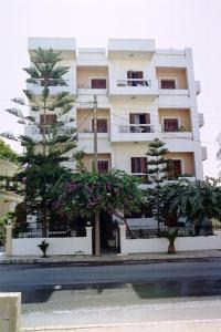 a tall white building with trees in front of it at Elena Studios in Chania