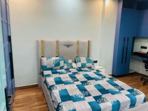 a bedroom with a bed with a blue and white quilt at Urban Retreat in New Delhi