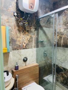 a bathroom with a glass shower and a toilet at Urban Retreat in New Delhi