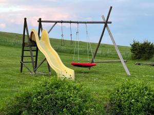 an empty swing set in a grassy field at Holiday home Hůrka in Hurka