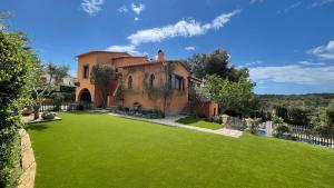 una casa con un ampio giardino con erba verde di Bellavista a Begur