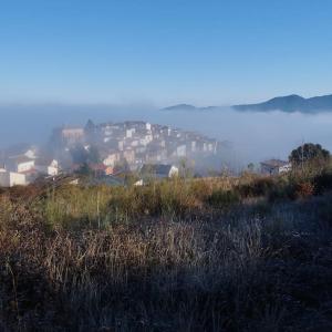 eine Gruppe von Häusern auf einem Hügel im Nebel in der Unterkunft Casa Calma en Sierra de Vicort, Zaragoza in Inogés