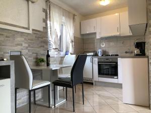 a kitchen with white cabinets and a table and chairs at Old city core in Senj
