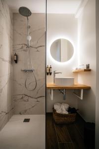 a bathroom with a shower with a sink and a mirror at Auberge du Lyonnais in Annecy