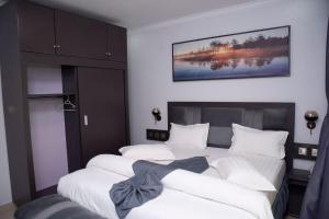 a bedroom with two beds and a painting on the wall at Grazia Apartments in Kigali