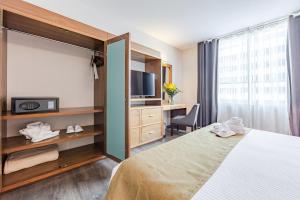 a bedroom with a bed and a tv and a desk at Suites Del Ángel in Mexico City