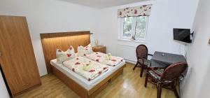 1 dormitorio con 1 cama, mesa y sillas en Penzion Ustie en Trstená