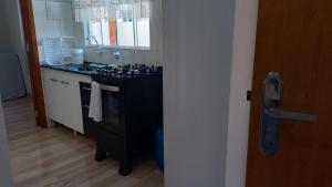 a kitchen with a black stove and a sink at AP 2 quartos e cozinha de uso exclusivo in Sorriso