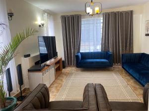 uma sala de estar com um sofá e uma televisão em Lifestyle Villas, Nanyuki em Nanyuki