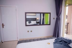 a bedroom with a bed and a mirror on the wall at Grazia Apartments in Kigali