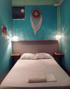 a bedroom with a bed with two lights on the wall at Kawoq Hostel in San Ignacio