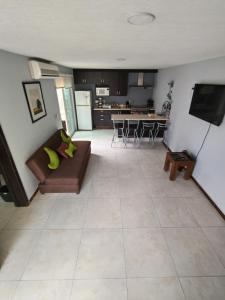 sala de estar con sofá y cocina en Casa Cerca estadio Akron y plaza del sol, en Guadalajara