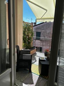 ラ・スペツィアにあるMaRiDeaの椅子と植物のあるパティオへと続く開放的なドア