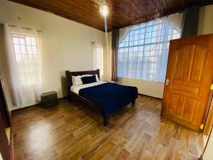 a bedroom with a bed and a large window at Lifestyle Villas, Nanyuki in Nanyuki