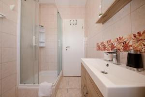 a bathroom with a shower and a white sink at Apartmani Ana & Milo in Lopar +90 photos