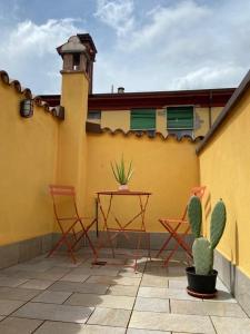 een patio met stoelen, een tafel en een cactus bij La Nicchia in Imola