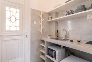 a kitchen with a sink and a microwave at Afluencia Complex Studio No 4,5,6 in Naousa