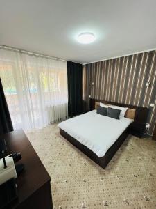 a bedroom with a large bed and a desk at Pensiunea Zimbrul in Poiana Brasov
