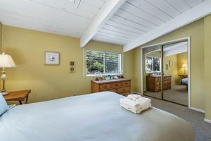 1 dormitorio con 1 cama blanca grande y espejo en Moosehead Manor en Aptos