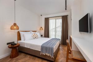 安塔利亞的住宿－AZUU BOHEM HOTEL，一间卧室设有一张床、一台电视和一个窗口。