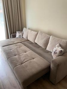 a large couch with two pillows on it in a room at South Beach Apartment at Valencia Gardens in Nesebar