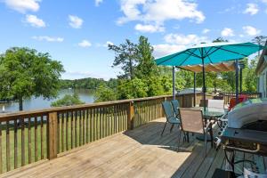 una terrazza con tavolo, ombrellone e griglia di Eatonton Home with Dock and Lake Sinclair Views! a Eatonton
