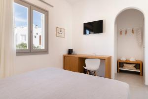 a bedroom with a bed and a desk and a window at Afluencia Complex Studio No 4,5,6 in Naousa