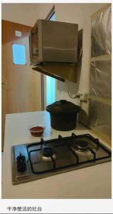 a stove top with a microwave on top of it at la madriguera in Raszyn