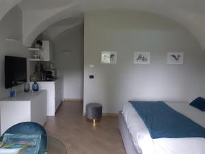 1 dormitorio con cama, mesa y TV en Sweet Home Canavese en Castellamonte