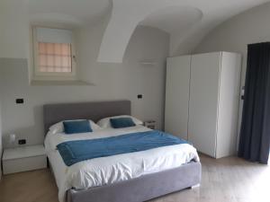 a bedroom with a large bed with blue sheets at Sweet Home Canavese in Castellamonte