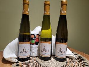 tre bottiglie di vino sedute sopra un tavolo di chambre gite au pied du Vieil Armand a Wattwiller