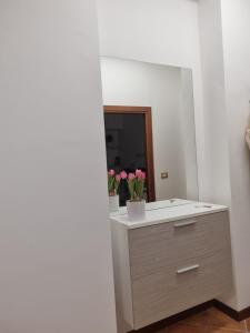 baño con lavabo y espejo con flores en Giardino Moreno, en Palermo