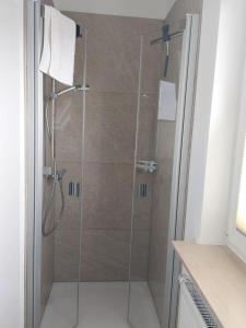 een douche met een glazen deur in de badkamer bij Ferienwohnung Lojane in Kranenburg