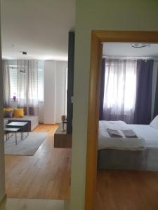 um quarto com uma cama e uma sala de estar em Sajam 1 em Novi Sad