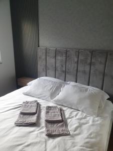 two towels sitting on top of a white bed at Sajam 1 in Novi Sad