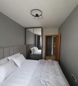 a bedroom with a large white bed and a mirror at Sajam 1 in Novi Sad