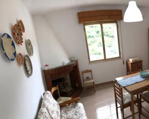 uma sala de estar com uma lareira e uma mesa em La Corbula - Casa Vacanze - Q5992 em Fluminimaggiore